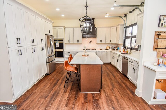 kitchen featuring sink, white cabinetry, a center island, a kitchen breakfast bar, and stainless steel appliances