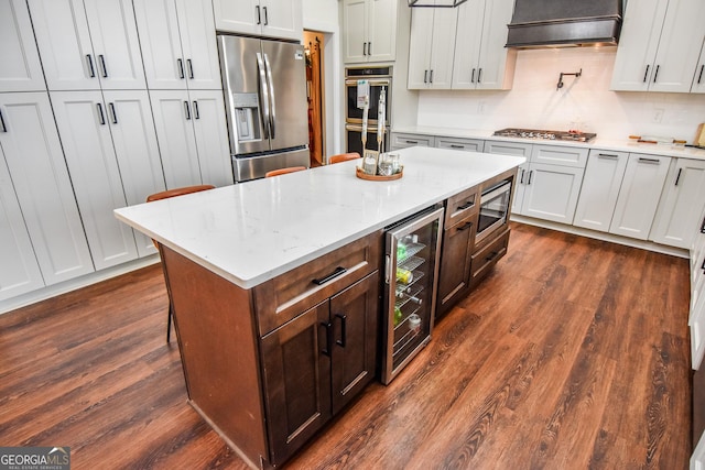 kitchen featuring wine cooler, white cabinetry, custom exhaust hood, and stainless steel appliances