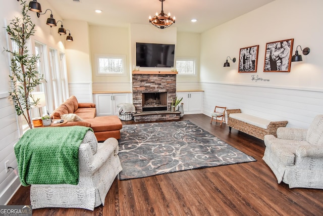 living room featuring a notable chandelier, a fireplace, and dark hardwood / wood-style flooring