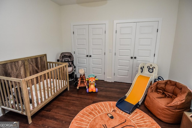 bedroom featuring a crib and dark hardwood / wood-style floors