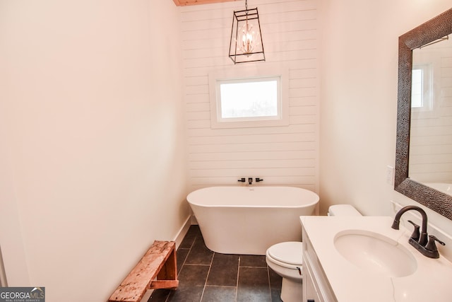 bathroom featuring a washtub, tile patterned flooring, plenty of natural light, and toilet