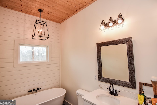 bathroom with toilet, wood ceiling, vanity, a bathing tub, and a notable chandelier