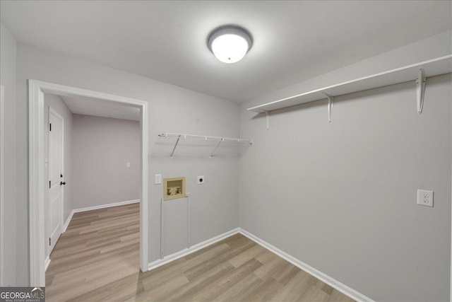 clothes washing area featuring electric dryer hookup, hookup for a washing machine, and light hardwood / wood-style flooring