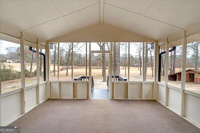 unfurnished sunroom featuring vaulted ceiling and a wealth of natural light