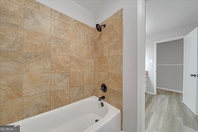 bathroom featuring tiled shower / bath combo and wood-type flooring