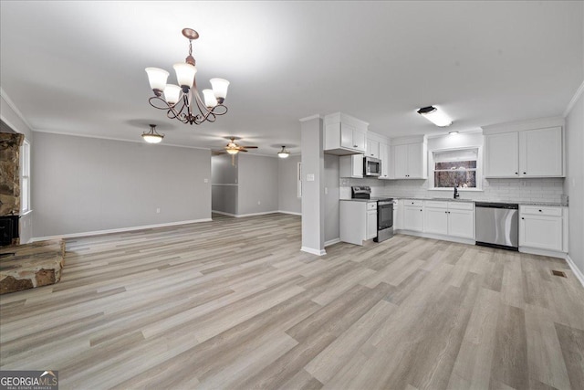 kitchen featuring sink, white cabinets, stainless steel appliances, light hardwood / wood-style floors, and backsplash