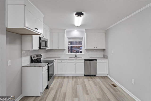 kitchen with white cabinetry, sink, light stone countertops, and appliances with stainless steel finishes