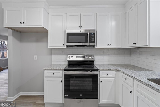 kitchen featuring light stone counters, appliances with stainless steel finishes, tasteful backsplash, and white cabinets