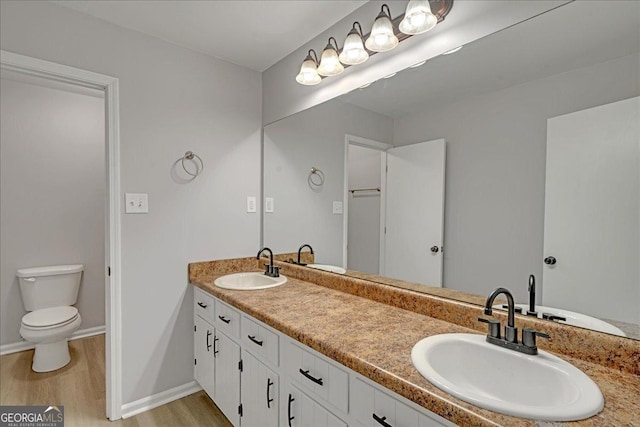 bathroom with wood-type flooring, toilet, and vanity