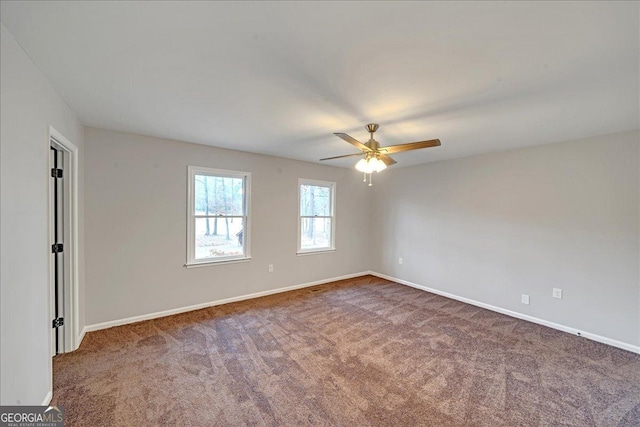 empty room featuring dark carpet and ceiling fan