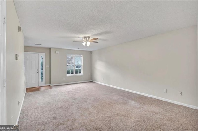 carpeted empty room featuring a textured ceiling and ceiling fan