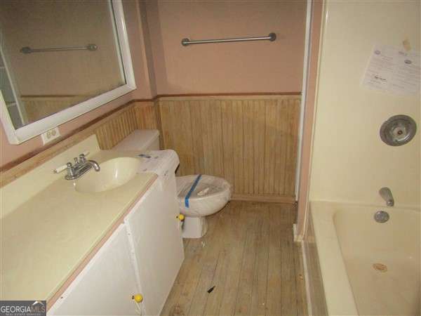 bathroom with wood-type flooring, toilet, and vanity