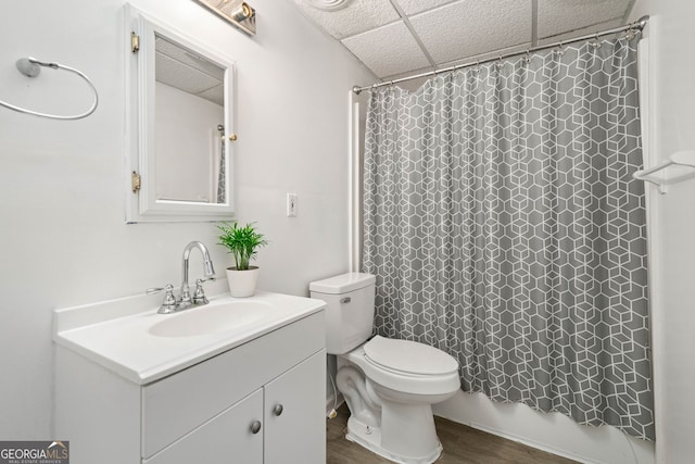 full bathroom with a paneled ceiling, wood-type flooring, vanity, toilet, and shower / bath combo