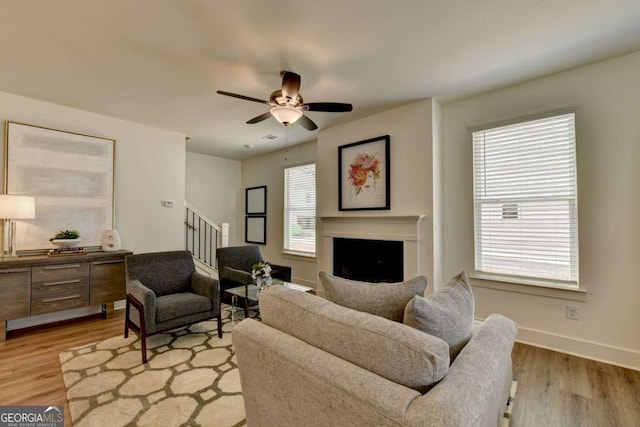 living room with ceiling fan and light wood-type flooring