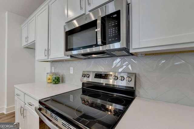 kitchen featuring appliances with stainless steel finishes, decorative backsplash, and white cabinets