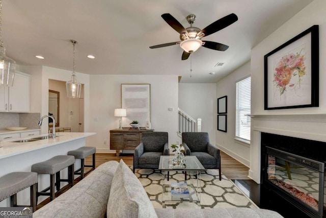 living room with ceiling fan, dark hardwood / wood-style flooring, and sink