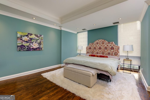 bedroom with visible vents, baseboards, wood finished floors, and ornamental molding