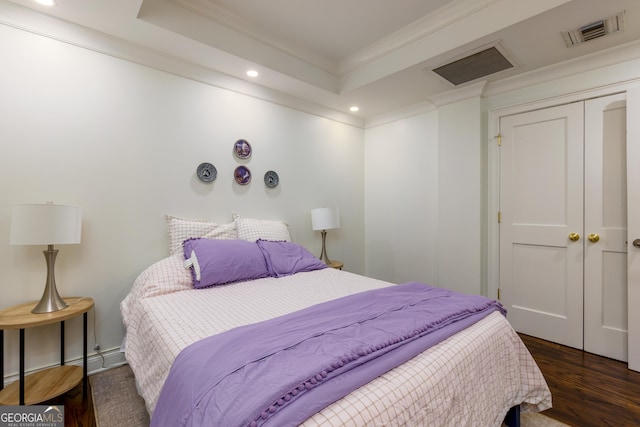 bedroom featuring visible vents, a tray ceiling, wood finished floors, recessed lighting, and crown molding