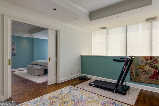 workout room with wood finished floors, visible vents, baseboards, crown molding, and a raised ceiling