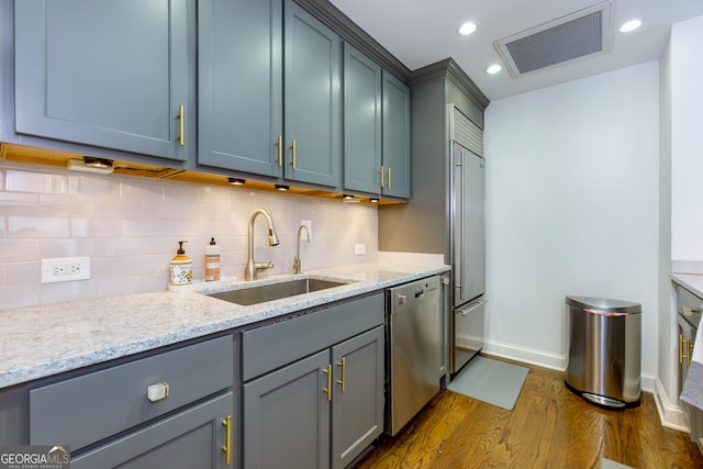 kitchen with visible vents, a sink, backsplash, dark wood-style floors, and appliances with stainless steel finishes