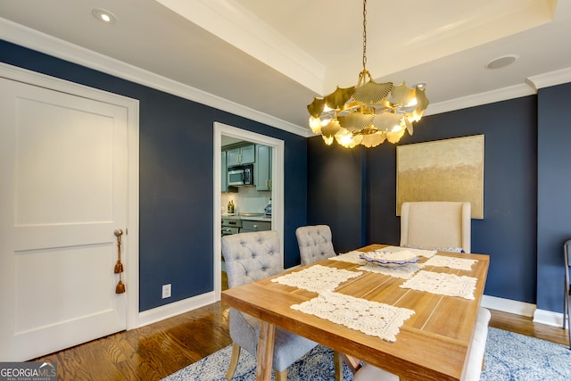 dining area featuring baseboards, a notable chandelier, wood finished floors, and crown molding