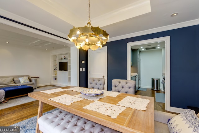 dining area with crown molding, baseboards, built in features, wood finished floors, and a notable chandelier