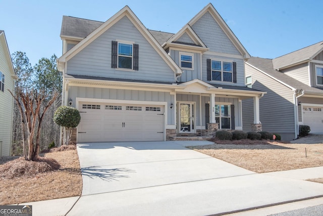 craftsman inspired home with a garage, driveway, a porch, and board and batten siding