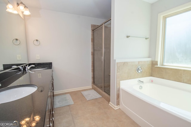 full bathroom featuring double vanity, a stall shower, baseboards, tile patterned floors, and a sink