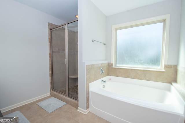 full bathroom with baseboards, tile patterned flooring, a bath, and a shower stall