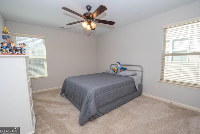 bedroom with baseboards, visible vents, and light colored carpet