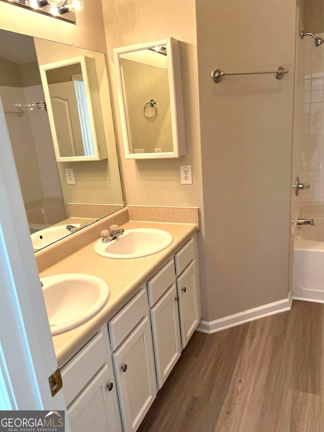 bathroom featuring vanity, wood-type flooring, and tiled shower / bath