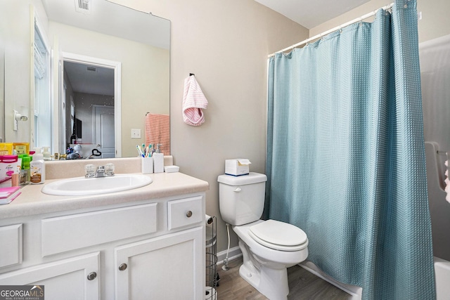 bathroom with wood-type flooring, vanity, and toilet