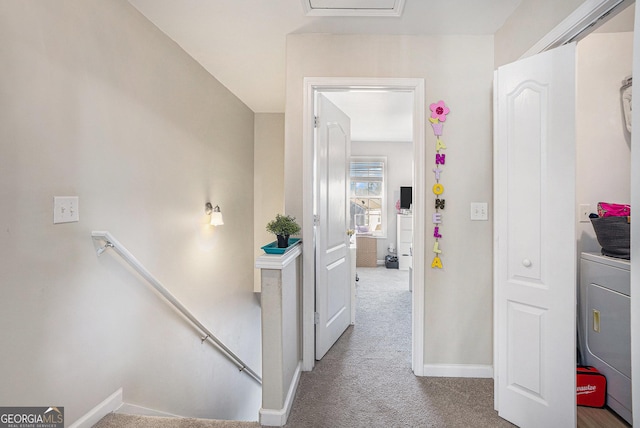 corridor with washer / dryer and light colored carpet