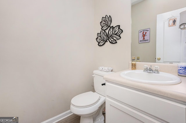 bathroom with hardwood / wood-style flooring, vanity, and toilet