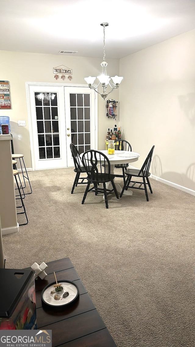 dining room featuring carpet flooring and a notable chandelier