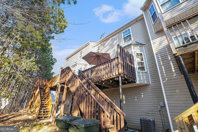 back of house with cooling unit and a wooden deck