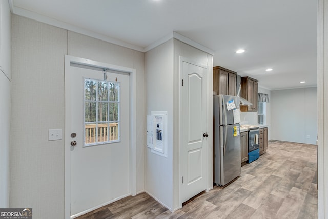 kitchen with crown molding, light wood finished floors, electric range, freestanding refrigerator, and dark brown cabinetry