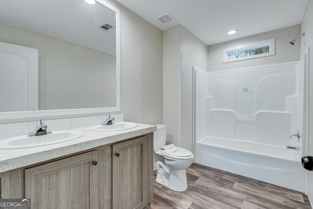 full bath featuring visible vents, a sink, toilet, and wood finished floors