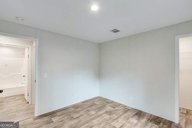 empty room with light wood-type flooring and visible vents