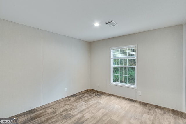 unfurnished room with visible vents and wood finished floors