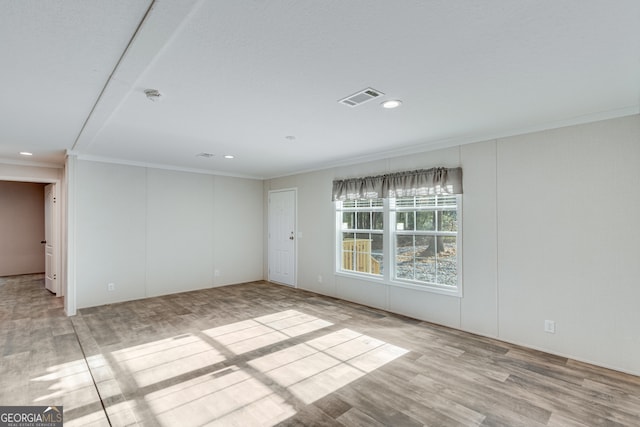 spare room featuring recessed lighting, visible vents, wood finished floors, and ornamental molding