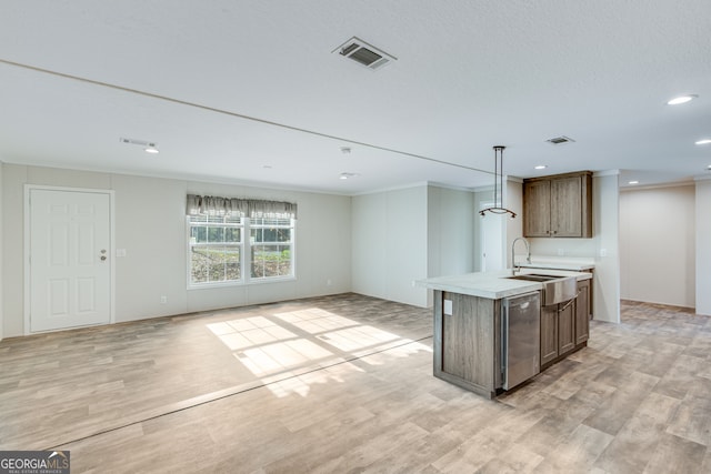 kitchen featuring visible vents, an island with sink, light wood-style flooring, light countertops, and a sink