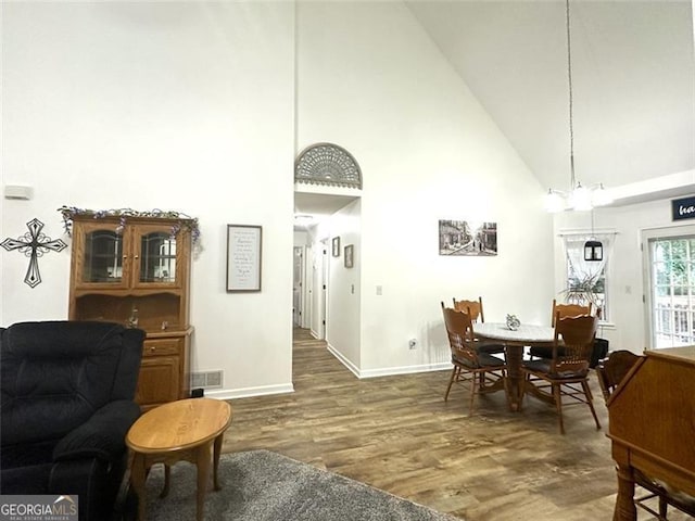 dining area with dark hardwood / wood-style flooring and high vaulted ceiling