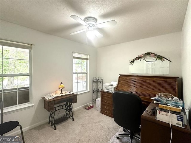 carpeted office space featuring ceiling fan and a textured ceiling