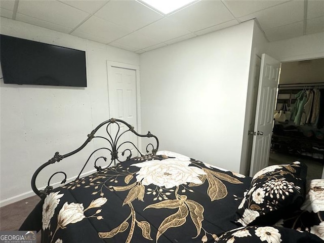 bedroom featuring a drop ceiling and a closet