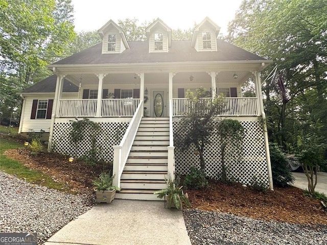 cape cod home featuring covered porch