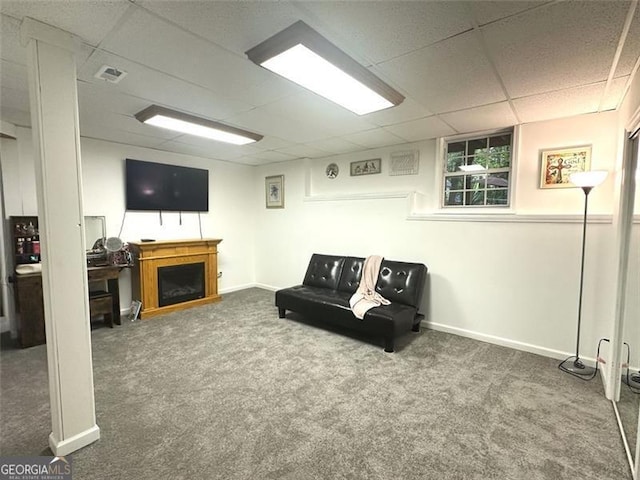 carpeted living room with a paneled ceiling