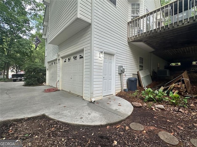 view of side of property featuring central AC unit, a garage, and a balcony