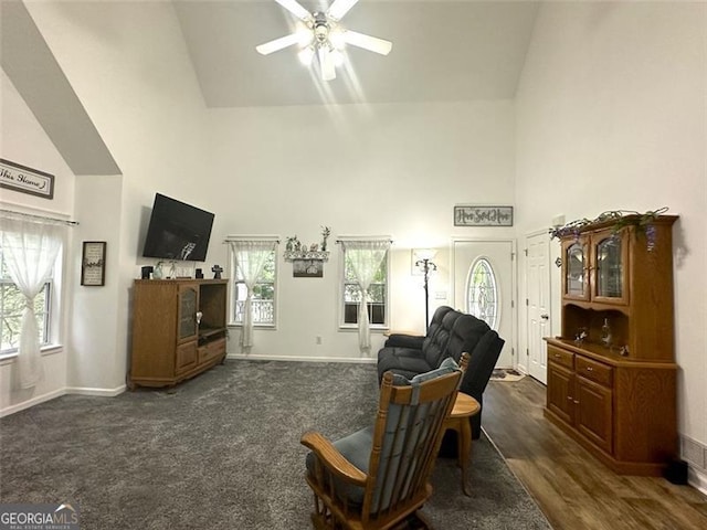 living area with dark carpet, ceiling fan, and high vaulted ceiling