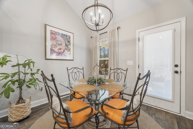 dining space featuring dark wood-style floors, lofted ceiling, a chandelier, and baseboards